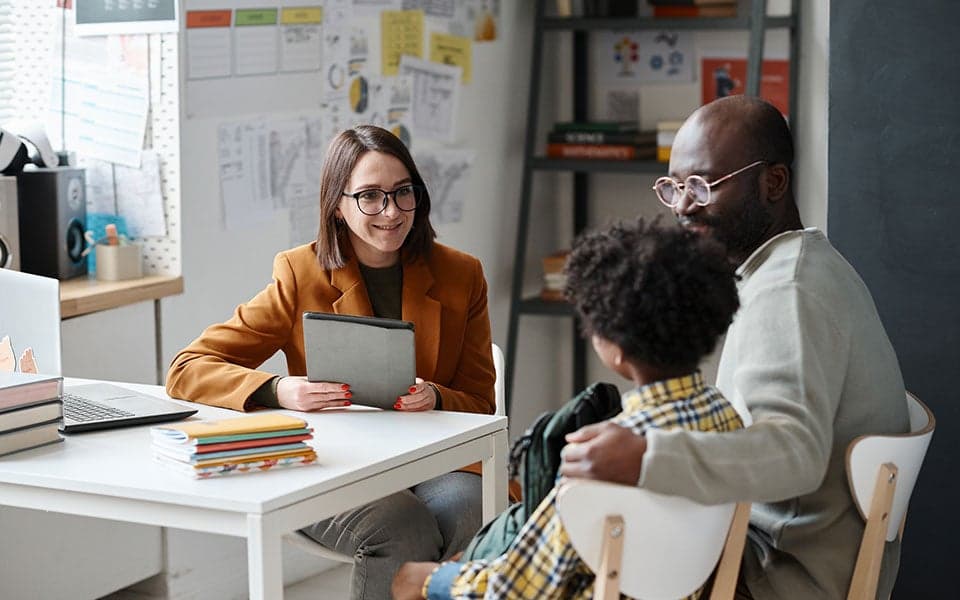 Teacher meeting with student and parent